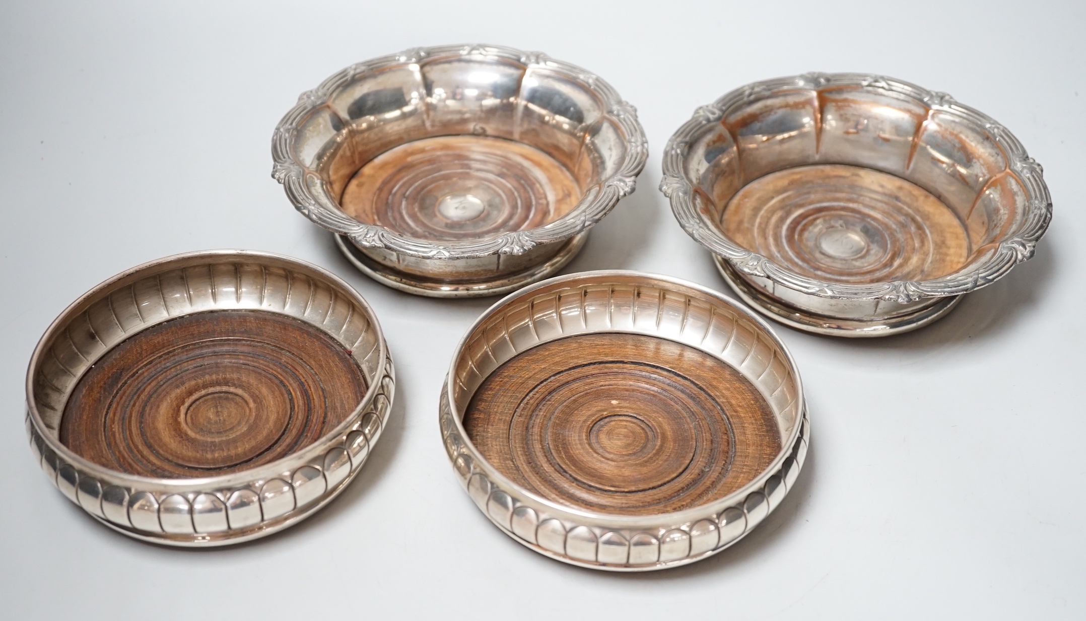 A pair of Elizabeth II silver wine coasters, London, 1973, diameter 13.4cm and a plated pair of wine coasters.